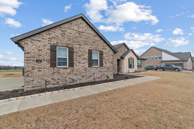 view of front of property featuring brick siding and a front lawn