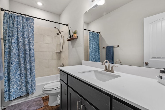 bathroom featuring vanity, wood finished floors, visible vents, toilet, and shower / tub combo with curtain