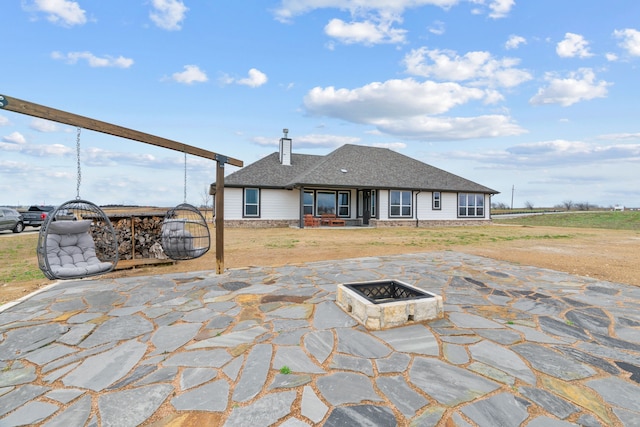 view of patio / terrace with an outdoor fire pit and a gate