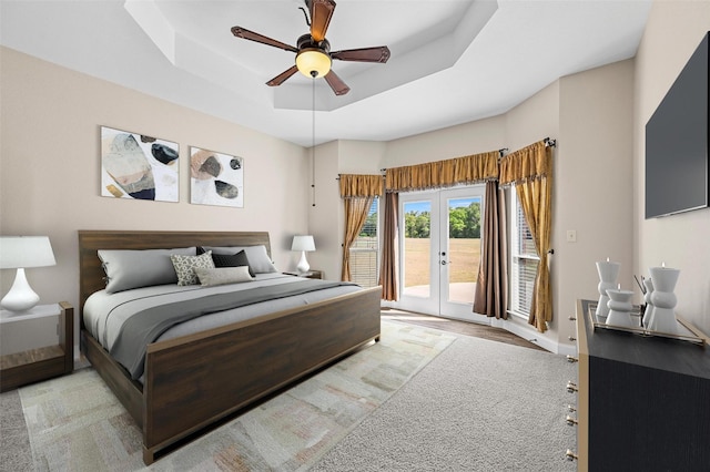 bedroom with baseboards, a tray ceiling, ceiling fan, french doors, and access to outside