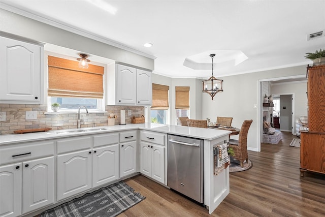 kitchen featuring tasteful backsplash, dishwasher, a peninsula, white cabinetry, and a sink