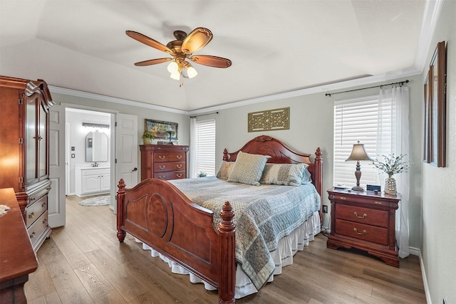 bedroom with a raised ceiling, multiple windows, wood finished floors, and ornamental molding