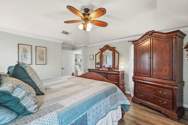 bedroom with visible vents, crown molding, baseboards, ceiling fan, and wood finished floors