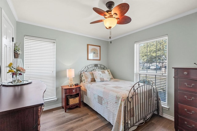 bedroom with ceiling fan, crown molding, baseboards, and wood finished floors