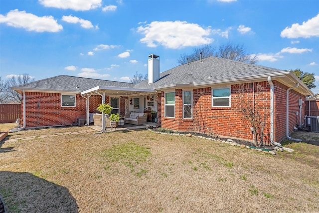 rear view of house featuring fence, a yard, outdoor lounge area, a patio area, and brick siding