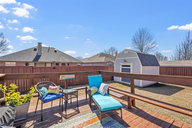 wooden terrace with an outbuilding, an outdoor hangout area, a storage unit, and a fenced backyard