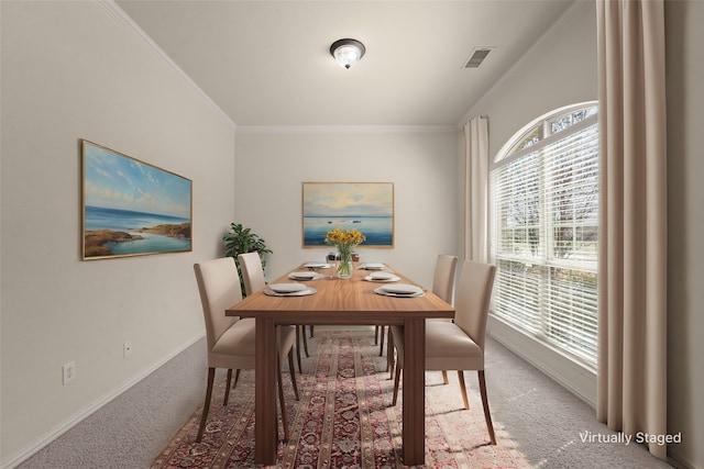 carpeted dining area with baseboards, visible vents, and ornamental molding