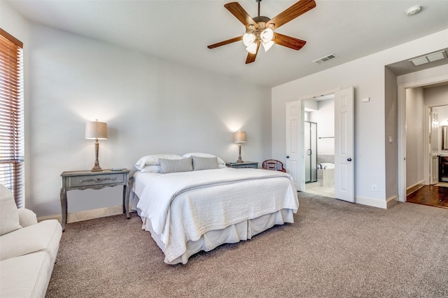 carpeted bedroom with visible vents, baseboards, ceiling fan, and ensuite bathroom