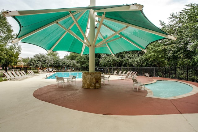 community pool featuring a patio and fence