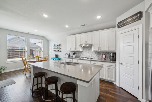 kitchen with visible vents, stainless steel gas cooktop, a sink, decorative backsplash, and under cabinet range hood