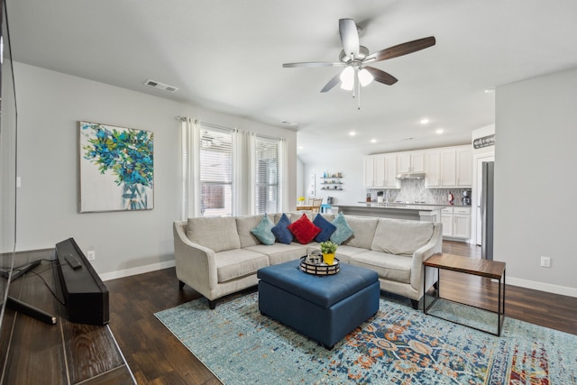 living room with dark wood-type flooring, baseboards, and visible vents