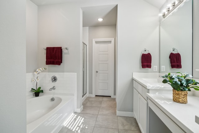 full bathroom featuring baseboards, a garden tub, double vanity, a stall shower, and tile patterned floors