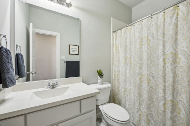 bathroom featuring a shower with curtain, toilet, and vanity