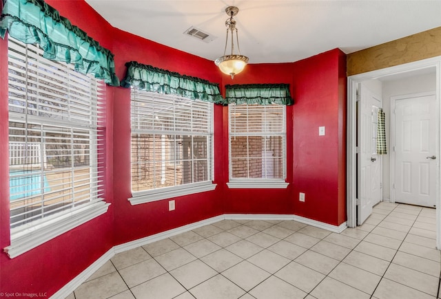 unfurnished dining area featuring light tile patterned flooring, baseboards, and visible vents