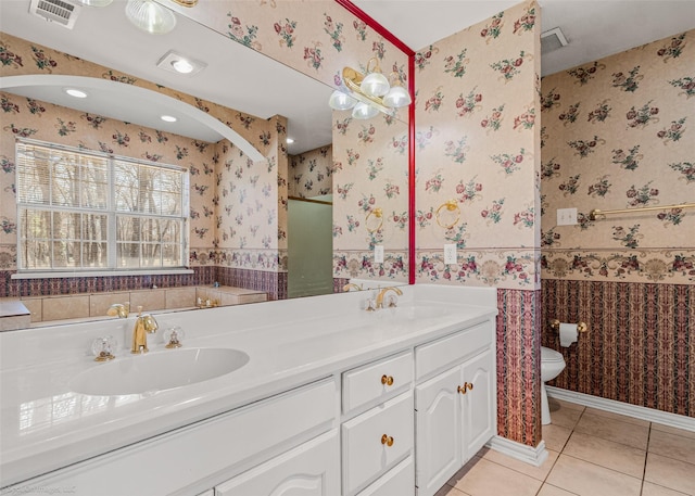 full bathroom with tile patterned flooring, toilet, wallpapered walls, and a sink