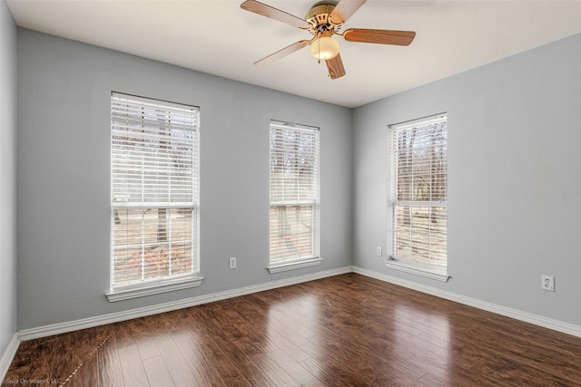 spare room featuring a ceiling fan, wood finished floors, and baseboards