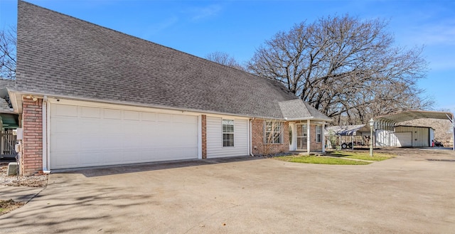 view of front of property with a garage, brick siding, roof with shingles, and concrete driveway