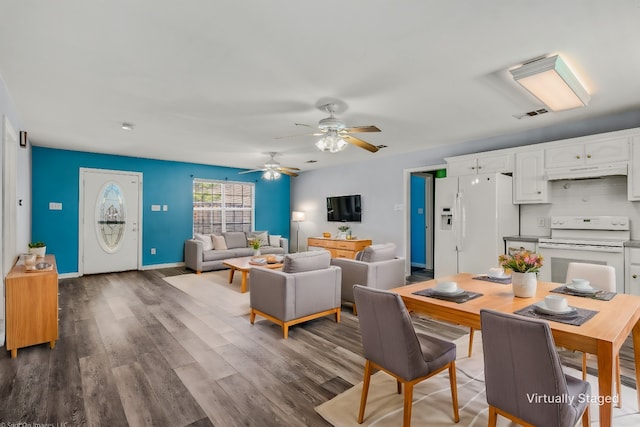 dining space with wood finished floors, visible vents, and baseboards