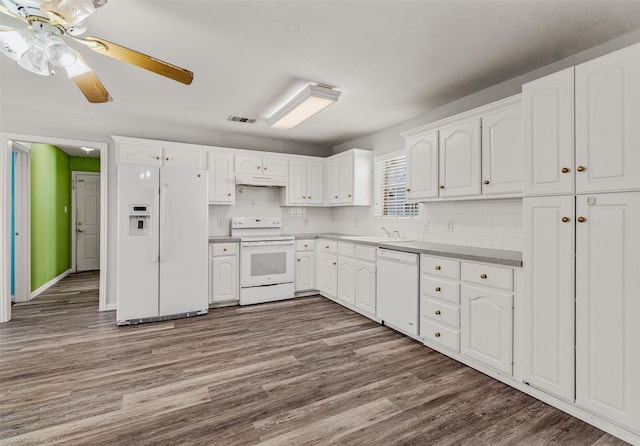 kitchen featuring white appliances, visible vents, dark wood finished floors, under cabinet range hood, and white cabinetry