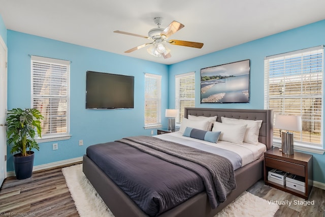 bedroom featuring a ceiling fan, wood finished floors, and baseboards