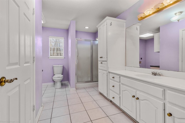 bathroom with tile patterned floors, toilet, a stall shower, baseboards, and vanity