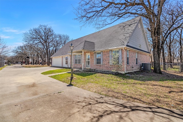 view of front of home with fence, concrete driveway, an attached garage, brick siding, and central AC unit