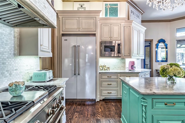 kitchen with tasteful backsplash, built in appliances, ornamental molding, range hood, and dark wood-style floors