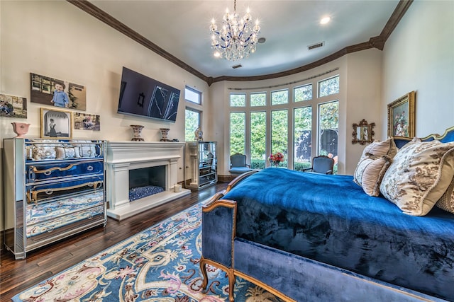 bedroom featuring crown molding, a fireplace with raised hearth, visible vents, and dark wood-style flooring