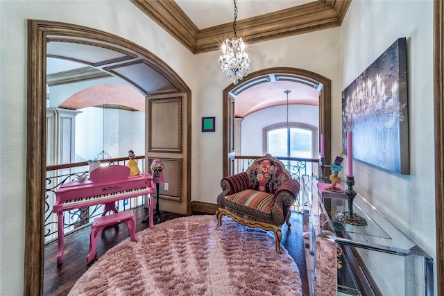 sitting room with baseboards, an inviting chandelier, wood finished floors, and crown molding