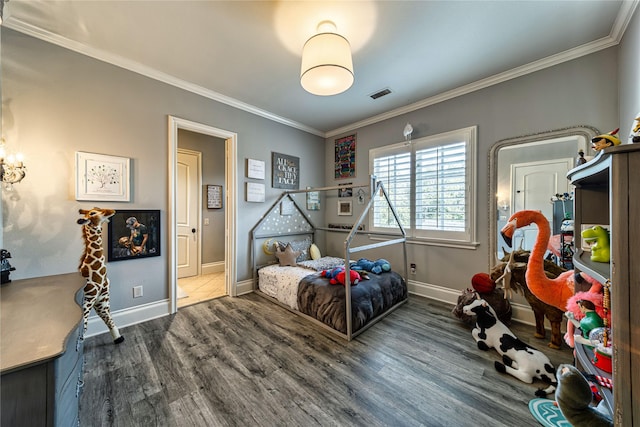 bedroom with visible vents, baseboards, wood finished floors, and crown molding