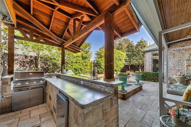 view of patio / terrace featuring outdoor wet bar, an outdoor kitchen, area for grilling, and a fenced backyard