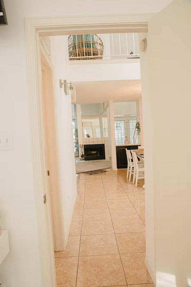 corridor featuring light tile patterned floors and baseboards