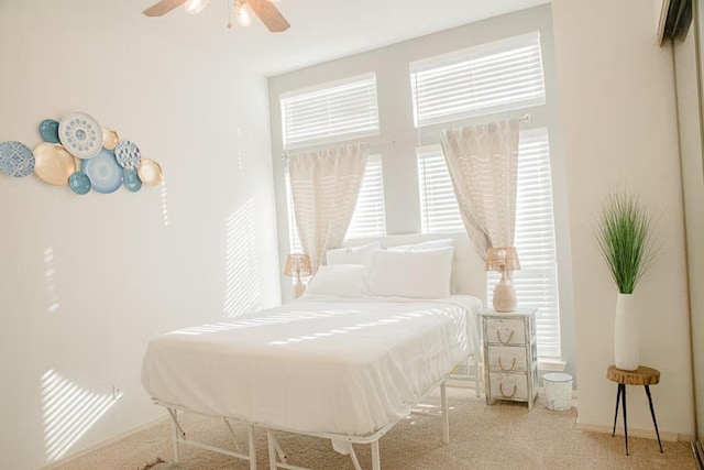 carpeted bedroom featuring baseboards and ceiling fan