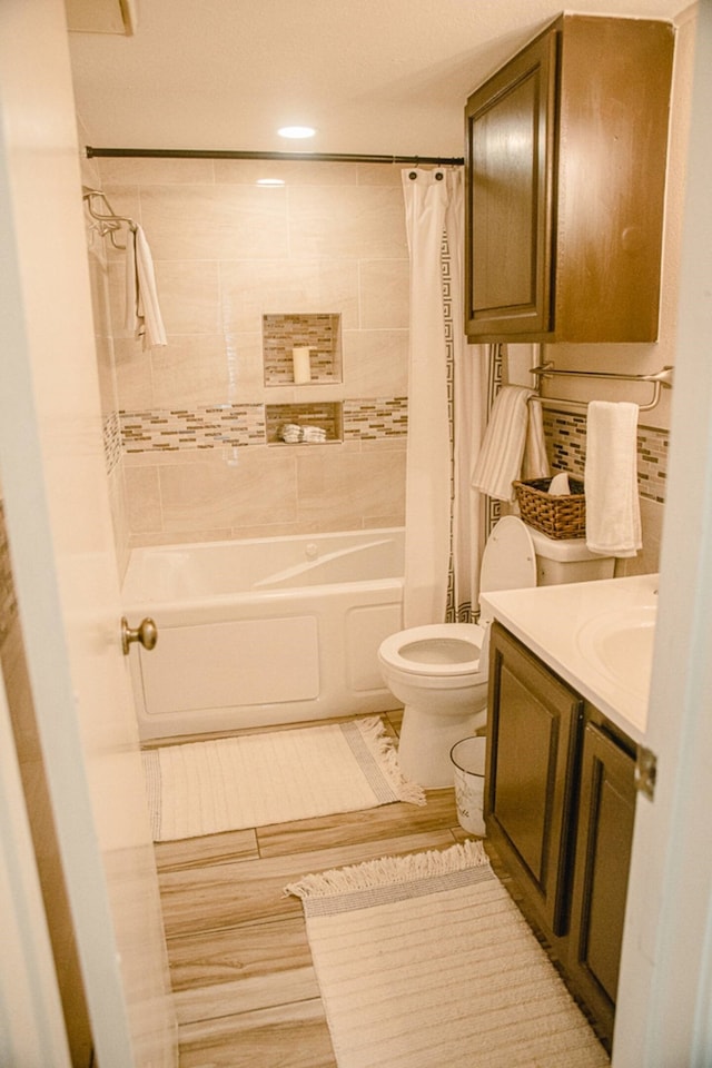 full bathroom featuring vanity, toilet, and shower / bathtub combination with curtain