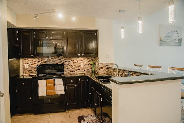 kitchen with dark countertops, decorative backsplash, light tile patterned flooring, black appliances, and a sink