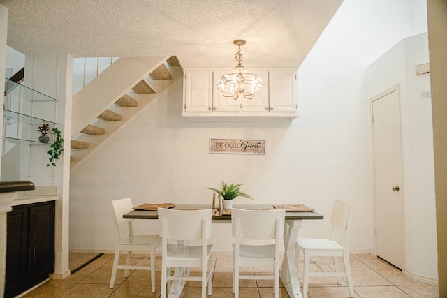 dining room with light tile patterned flooring, a notable chandelier, stairway, and a textured ceiling