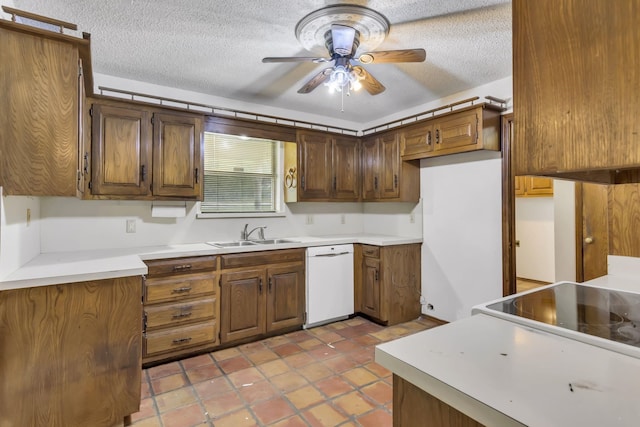 kitchen with a sink, a textured ceiling, light countertops, and white dishwasher
