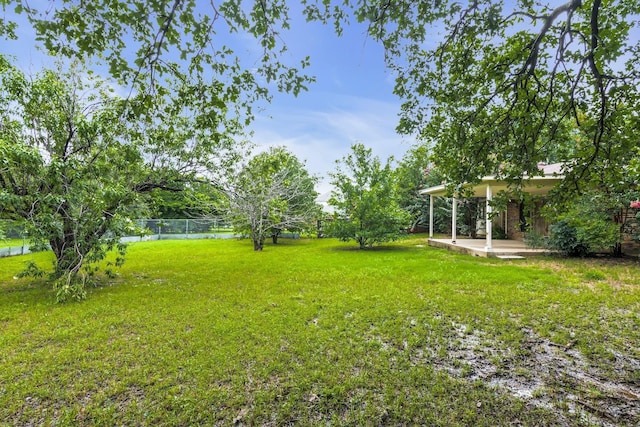 view of yard with a patio area, fence, and a water view