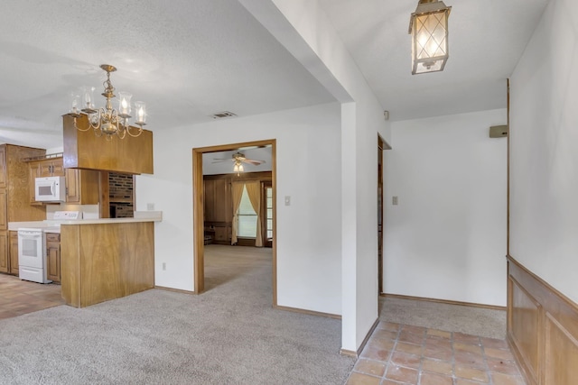 kitchen featuring visible vents, light colored carpet, light countertops, brown cabinetry, and white appliances