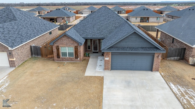 view of front of house with a residential view, brick siding, roof with shingles, and concrete driveway