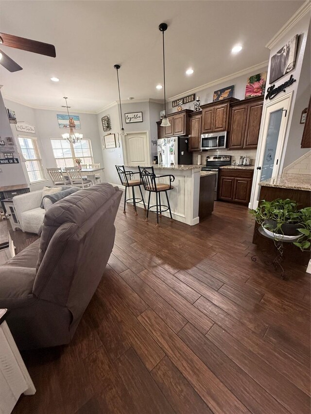 living area with recessed lighting, dark wood-style floors, crown molding, and ceiling fan with notable chandelier