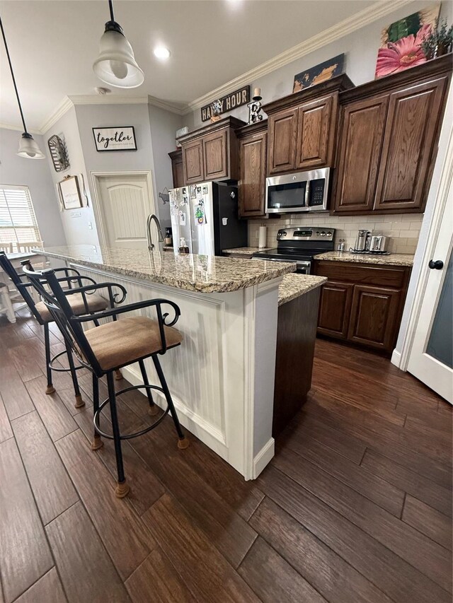 kitchen featuring dark wood finished floors, crown molding, backsplash, and stainless steel appliances