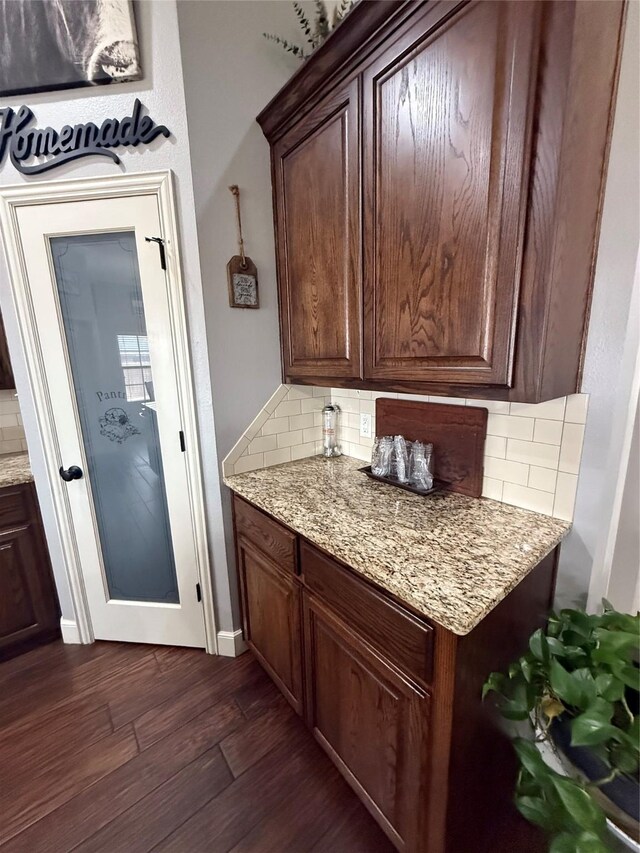 kitchen featuring dark brown cabinetry, backsplash, and dark wood finished floors