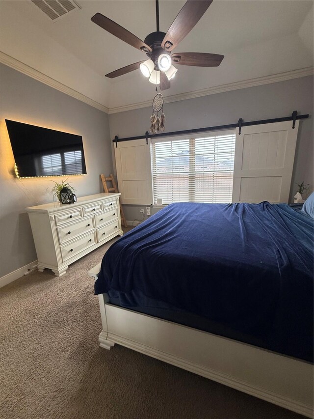 bedroom featuring visible vents, crown molding, baseboards, a barn door, and carpet floors