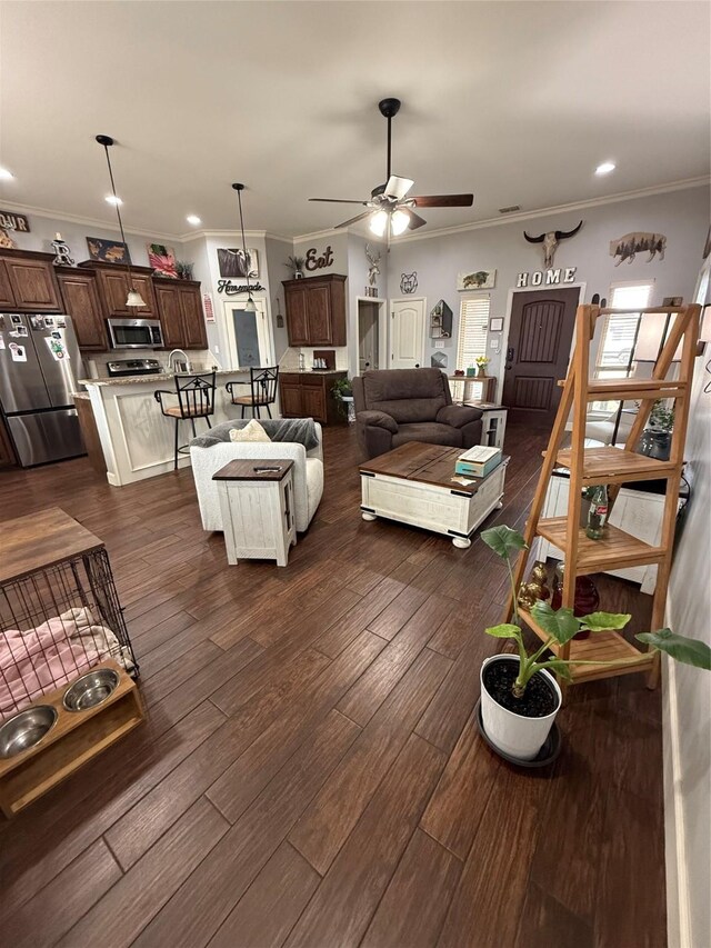 living area featuring visible vents, crown molding, baseboards, and dark wood-style flooring