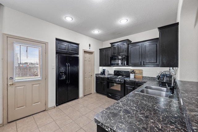 kitchen featuring light tile patterned floors, black appliances, dark cabinetry, and a sink