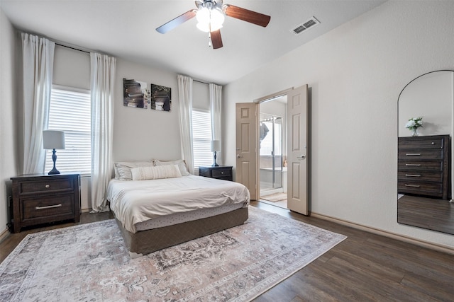 bedroom with multiple windows, wood finished floors, visible vents, and connected bathroom