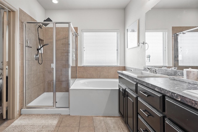 full bath with tile patterned floors, a shower stall, a bath, and a sink