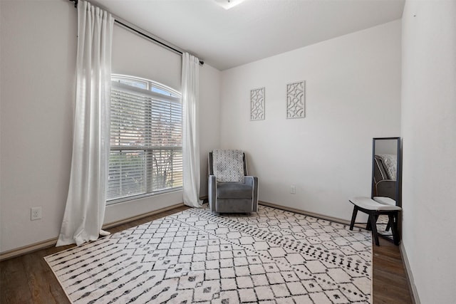 sitting room with baseboards and wood finished floors