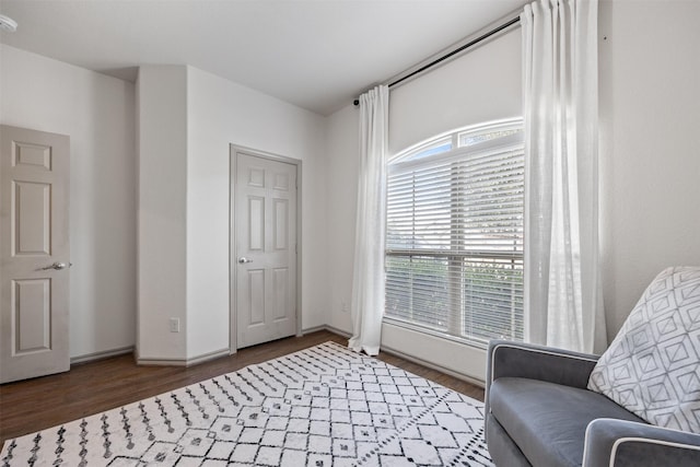 living area with baseboards and wood finished floors